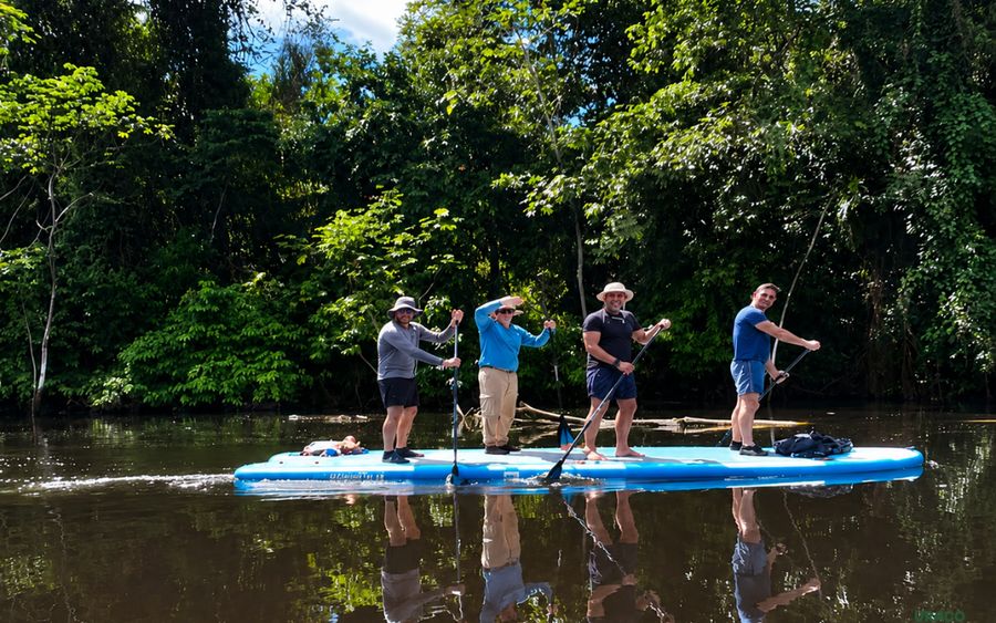 Grupo practicando stand up paddle en el rio
