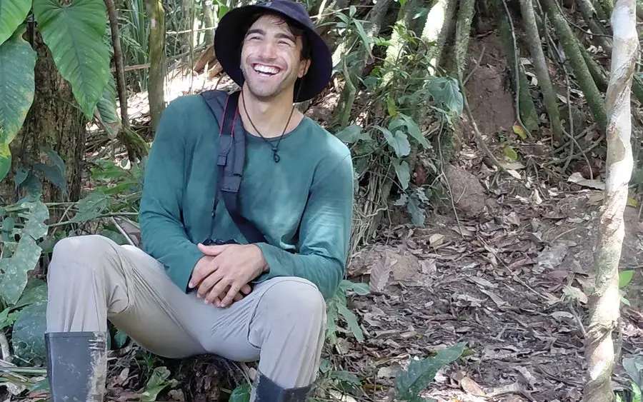 Smiling traveller resting during a rainforest walk